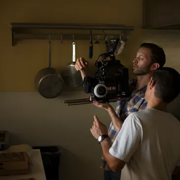 Two men are filming a cooking show.