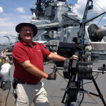 A man standing on the deck of an aircraft carrier.