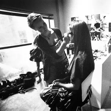 A woman is getting her hair done by another person.