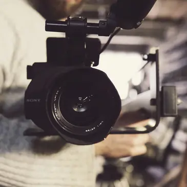 A person is holding a video camera up to the lens.