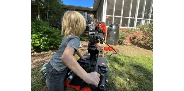 A little girl is playing with a machine.