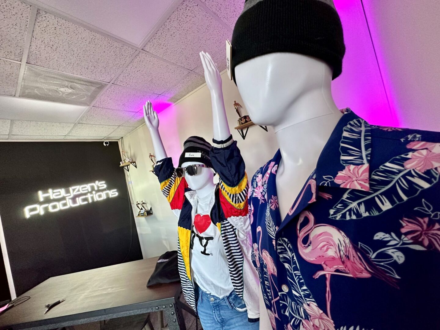 Two mannequins are wearing hats and jackets.