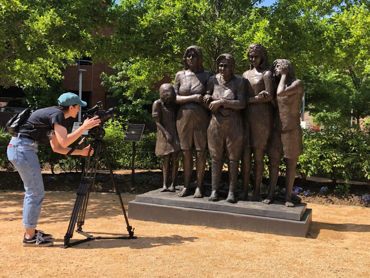 A man is taking pictures of statues in the park.