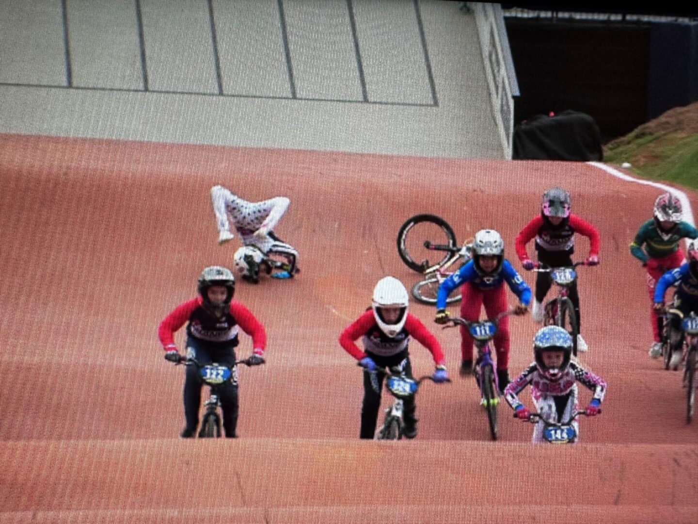 A group of people riding bikes on top of a dirt field.