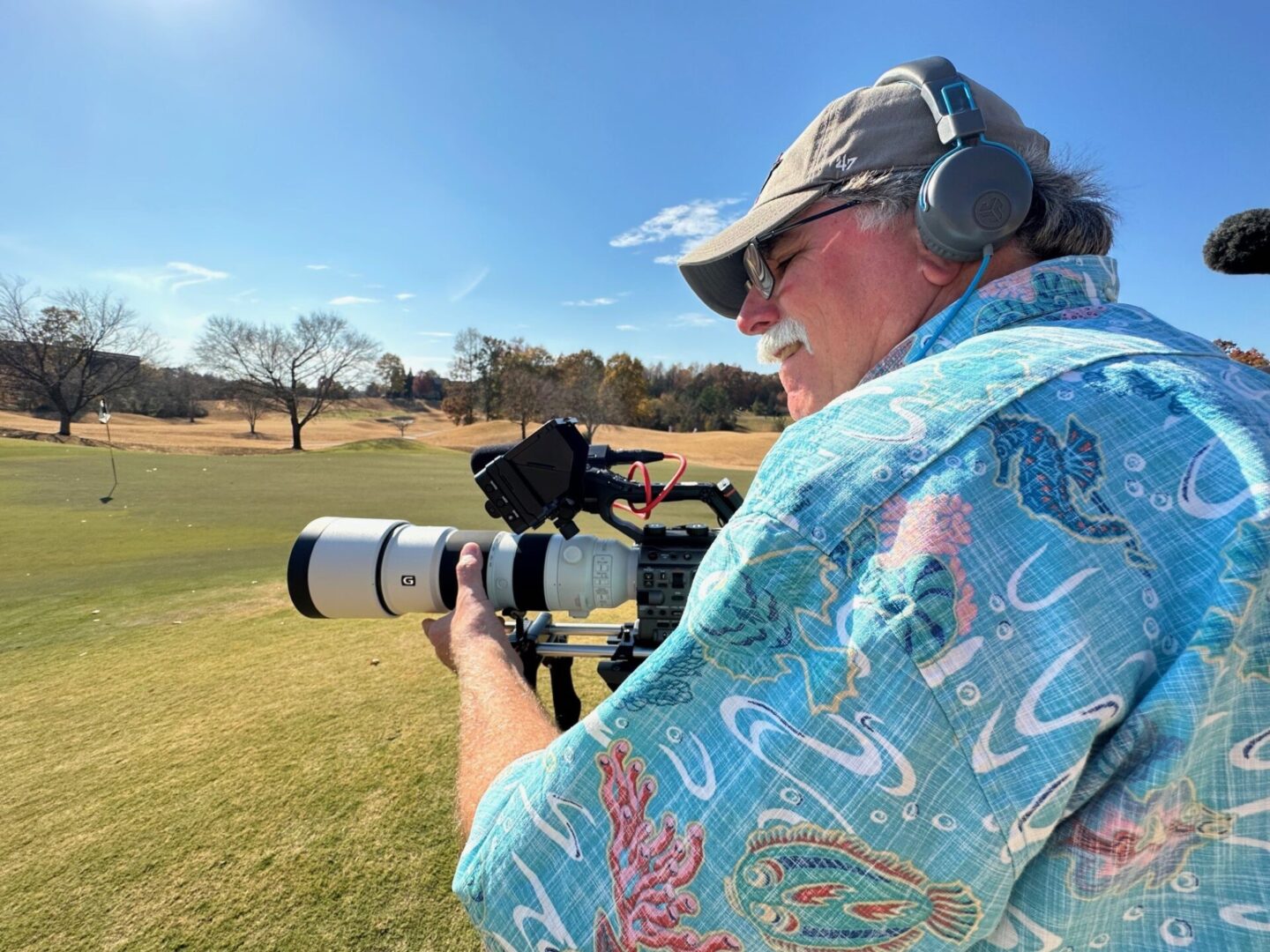 A man with headphones and a camera in his hand.