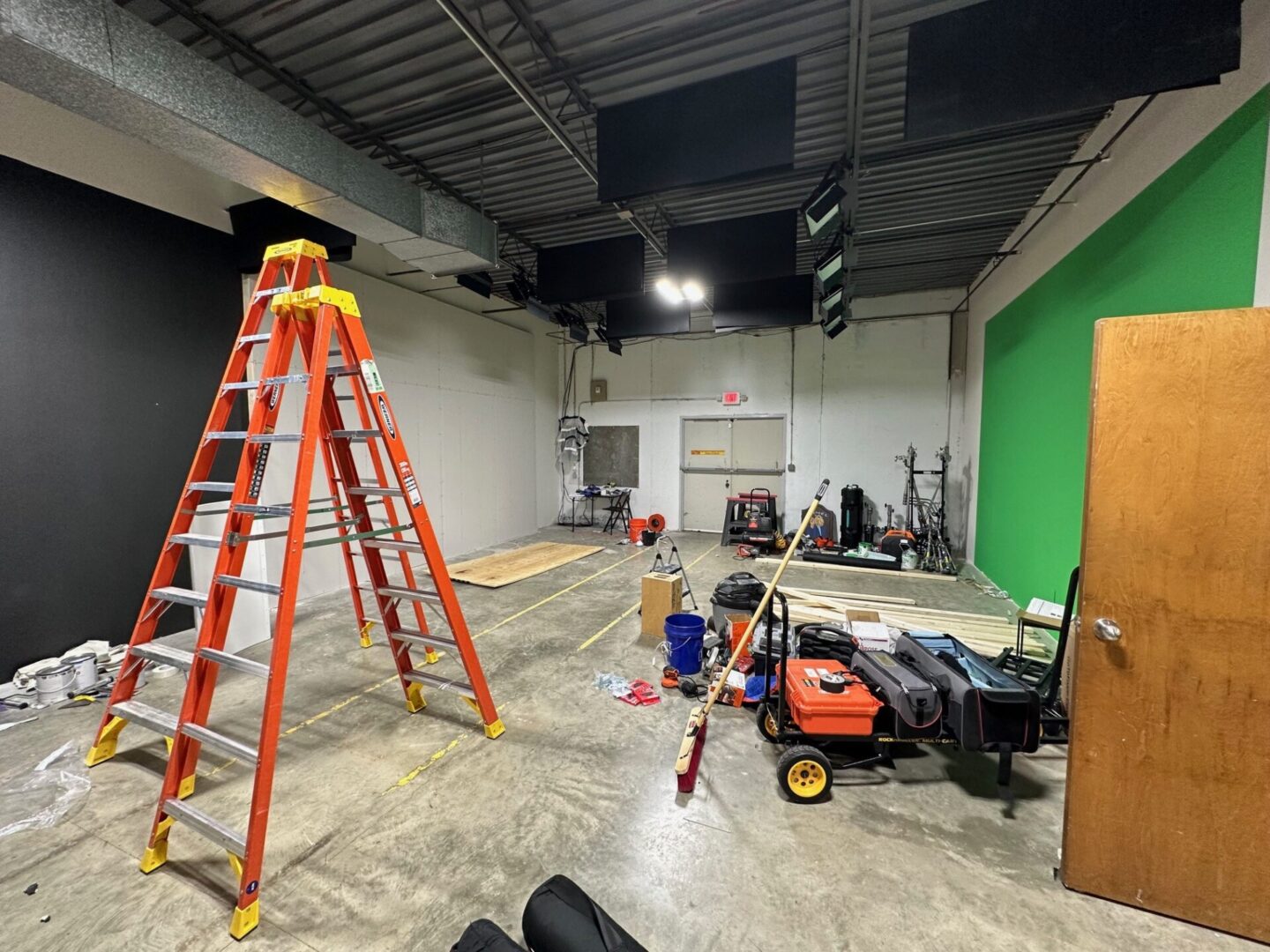 A room with ladders and other construction equipment.