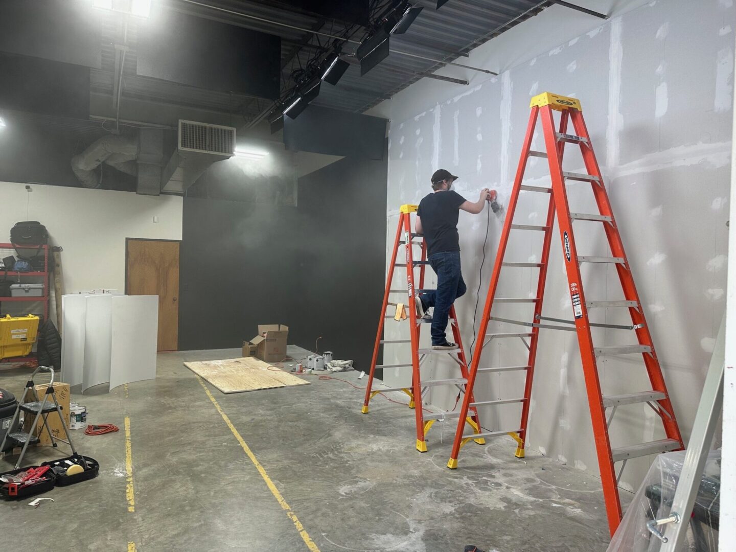 A man is painting the wall of an empty room.