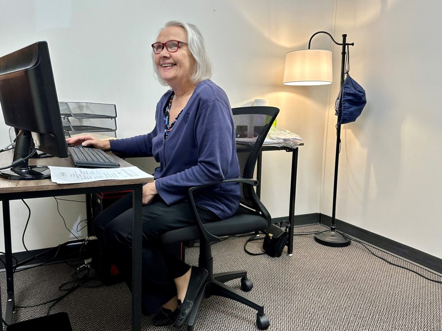 A woman sitting at her desk with a laptop.