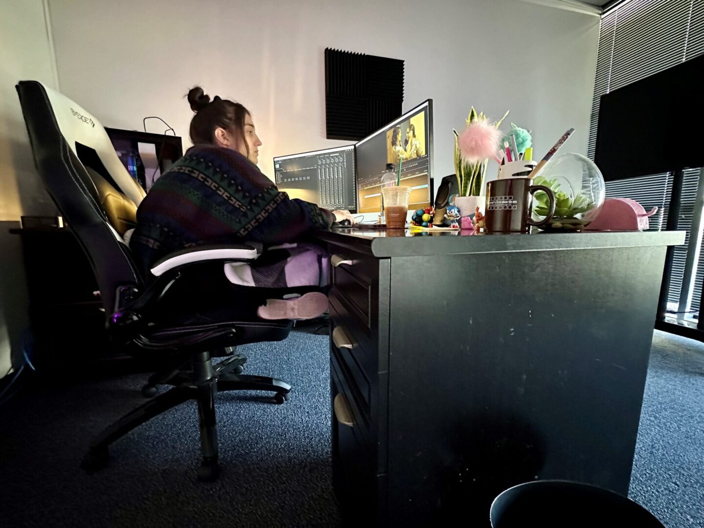 A person sitting at a desk with two monitors.