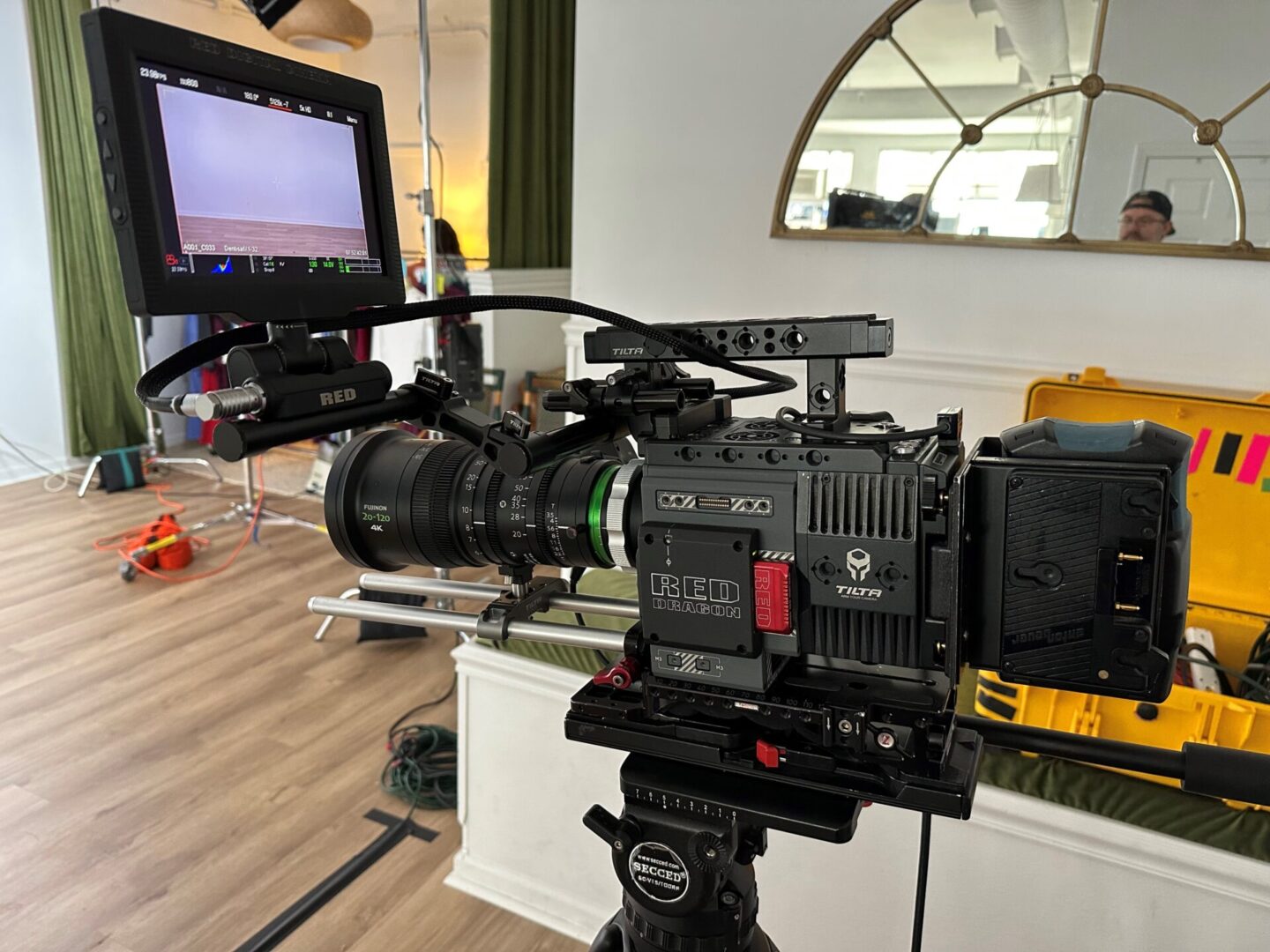 A camera on top of a tripod in front of a mirror.