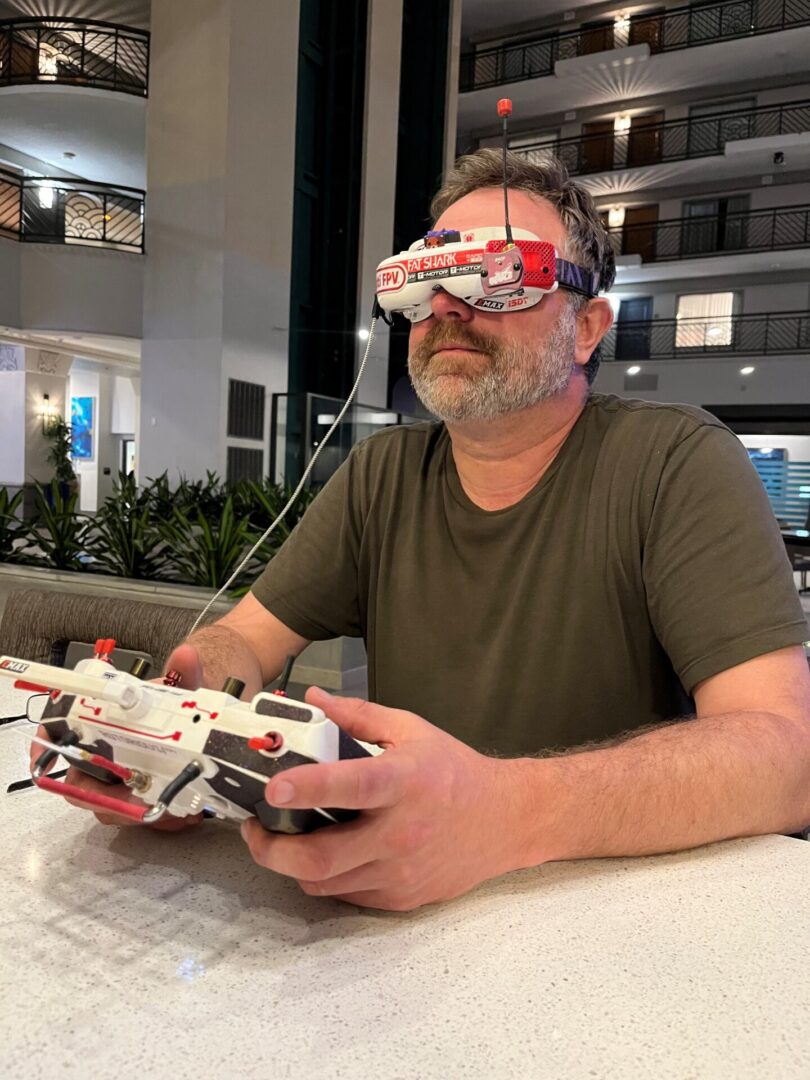 A man sitting at a table with a remote control.