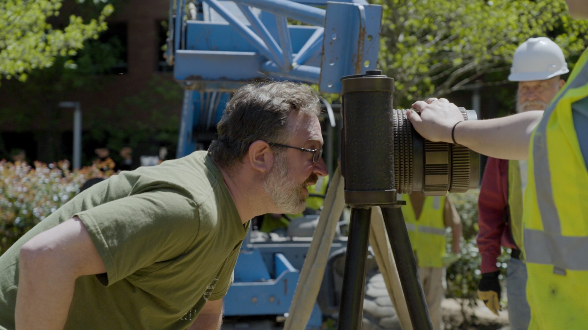 A man looking through the lens of a camera.