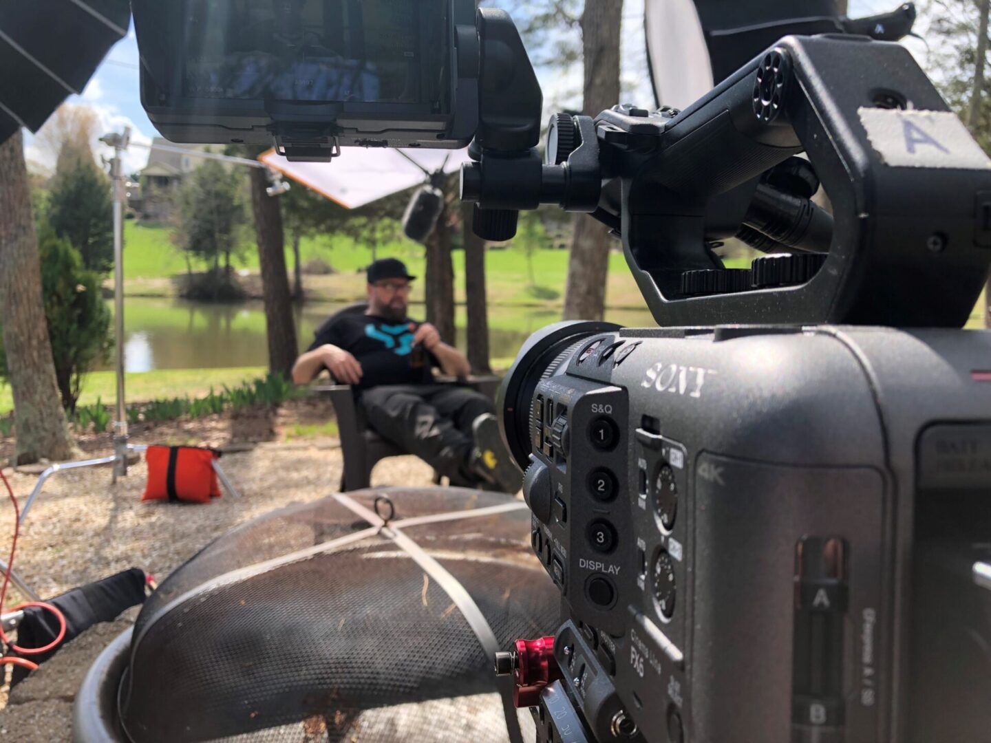 A man sitting on the ground in front of a camera.